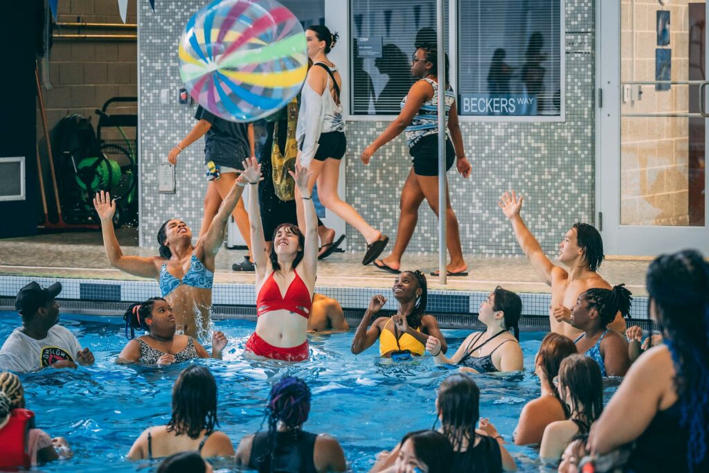Students playing with a beach ball at the Spartanfest pool party