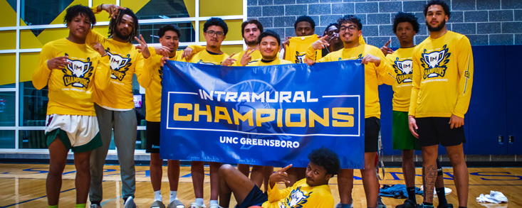 intramural basketball champions posing with banner