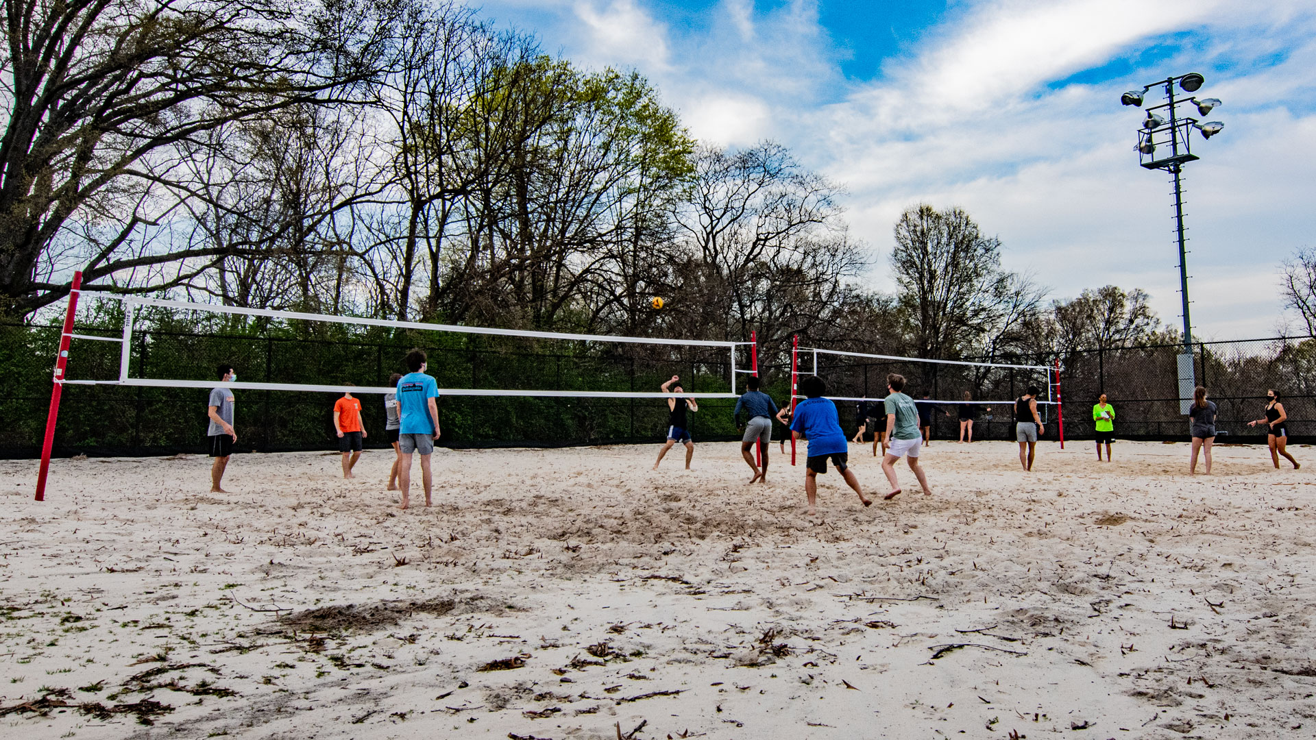 students playing sand volleyball on a sunny day