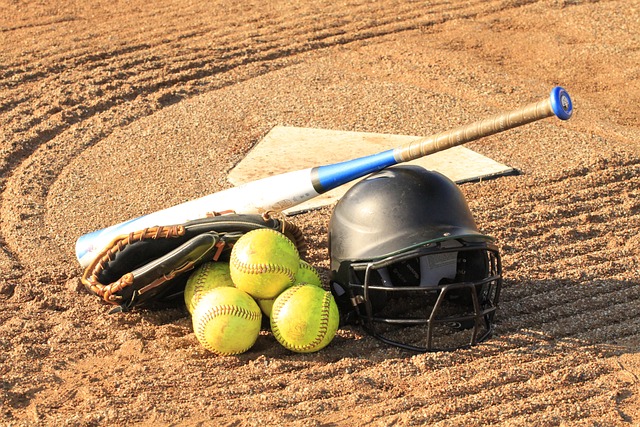 softballs, batting helmet, and bat placed by home plate.